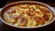 © valeo5 - Delicious close-up of a freshly baked potato gratin (scalloped potatoes/dauphinois) in a ceramic dish, featuring creamy sauce and a bubbly, golden-brown caramelized cheese and potato crust.