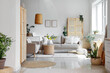 © Pixel-Shot - Comfortable beige sofas, wicker table and houseplants in interior of living room