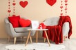 © Pixel-Shot - Interior of festive living room with grey armchairs, coffee table and hearts. Valentine's Day celebration