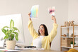 © Pixel-Shot - Female interior designer working with color palettes at table in office