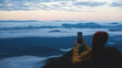© Farknot Architect - Blurred rear view of a female traveler taking photo of a beautiful foggy mountain before sunrise