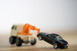 © seanzheng - toy tow truck towing black car.
