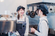 © maroke - 楽しく業務内容を教えてもらう飲食店アルバイトの女性
