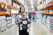© leungchopan - Mother carrying baby walking in supermarket