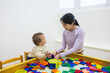 © leungchopan - Mother and baby playing with magnet tile indoors
