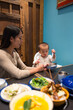 © leungchopan - Mother feed baby boy at restaurant table