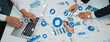 © InfiniteFlow - A team engages in a collaborative business management session, analyzing data and presenting strategies using charts and graphs in a modern office setting. Amity