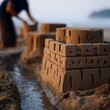 © LEXI Studio - Detailed sandcastle on the beach with blurred background.