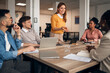 © Jelena - Group of Professionals Collaborating During an Office Meeting
