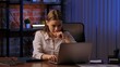© kinomaster - Focused Woman Working Late on Laptop in Office Environment