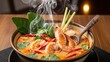 © photoplotnikov - Steaming bowl of spicy tom yum soup with shrimp and lemongrass garnish