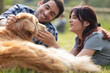 © auremar - beautiful couple cuddling and walking dogs outdoors in park
