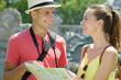 © auremar - smiling couple in love traveling with a map outdoors