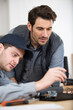 © auremar - man and apprentice repairing broken smartphone in workshop