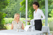 © auremar - waitress serving food to smiling women in restaurant