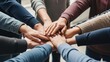 © asmi - Diverse group of people putting hands together in a huddle, symbolizing teamwork and unity.