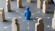 © photo for everything - A central blue figure is surrounded by wooden figures, connected with arrows, symbolizing influence, leadership, or a hub of information in a network.