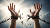 Hands breaking free from chains against a bright, dramatic sky symbolizing freedom and liberation concept