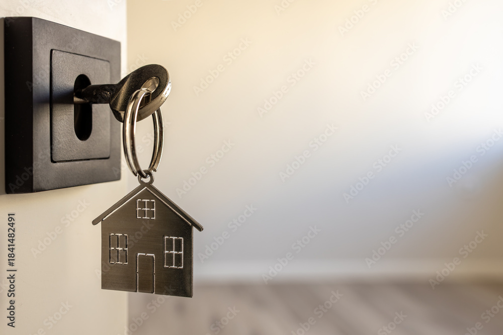 Open door to a new home. Door handle with key and home shaped keychain. Mortgage, investment, real estate, property and new home concept