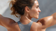© JoeyMarut - Close up of athletic woman with toned back and arms, wearing gray sportswear, smiling confidently outdoors in natural sunlight, healthy lifestyle and fitness motivation
