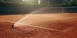 © TheWaterMeloonProjec - Tennis court surface being irrigated, emphasizing upkeep and water management