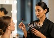 © Jafree - Woman makeup artist applying cosmetic on client in studio. Professional beauty procedure for transformation. Glamour industry concept.