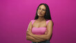 © Krakenimages.com - Young woman wearing glasses and pink top, arms crossed revealing bare shoulders and chest with head tilt and contemplative gaze in pink studio; thoughtful introspection.
