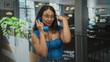 © Krakenimages.com - Young hispanic woman holds vintage telephone handset to ear and points finger to temple in a building; playful nostalgia.