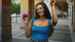 © Krakenimages.com - Woman holding a red heart and pointing finger on a street, smiling and wearing glasses and denim; love health awareness joy.
