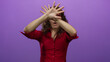 © Krakenimages.com - Woman gesturing expressively against an isolated purple wall, wearing a red shirt and glasses, showcasing emotion in a vibrant and energetic manner.