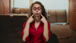 © Krakenimages.com - Woman making funny face indoors at construction site, wearing red shirt and glasses, surrounded by unfinished walls and warm lighting, reflecting a playful and humorous mood.