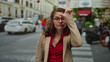 © Krakenimages.com - Woman wearing glasses and making a gesture while standing on a busy city street surrounded by cars and buildings.