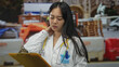 © Krakenimages.com - Woman doctor with stethoscope examining clipboard at construction site, displaying concern while wearing a uniform outdoors, embodying medical professionalism in an unconventional setting.