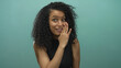 © Krakenimages.com - Latin woman smiling and talking over isolated blue background with curly hair, dressed in black, showcasing expressive emotions in a vibrant setting perfect for creative projects
