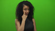 © Krakenimages.com - Woman gestures thoughtfully against a vibrant green background, conveying emotion and expression.