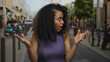 © Krakenimages.com - Woman expressing surprise outdoors on busy street, showcasing vibrant urban scene with energetic emotion amidst lively city backdrop blending into a colorful environment.