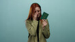 © Krakenimages.com - Woman crying holding a chinese passport against a blue background, conveying travel-related emotions and challenges.