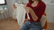 © Krakenimages.com - Woman holding baby clothes in bedroom, expressing care in a comfortable home setting with soft lighting, suggesting preparation and nurturing indoors.