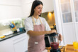 © Mediteraneo - Young Woman Making Smoothie at Home