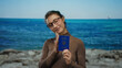 © Krakenimages.com - Young woman holding ukrainian passport at seaside, smiling with ocean backdrop, suggesting travel or tourism, with a sense of freedom and tranquility outdoors.