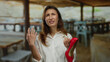 © Krakenimages.com - Woman expressing frustration at a terrace restaurant while holding a red shoe, capturing a moment of outdoor dining and emotion under the rustic wooden canopy.