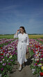 © Krakenimages.com - Woman strolling through a vibrant tulip field in lisse, netherlands, wearing a white dress, holding a basket, and enjoying the sunny day.