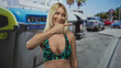 © Krakenimages.com - Woman with bare chest giving thumbs up next to recycling container on street; environmental encouragement approval.