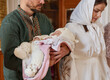 © New Africa - Father holding his child during baptism ceremony in church, closeup