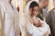 © New Africa - Mother holding her child during baptism ceremony in church