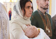 © New Africa - Mother holding her child during baptism ceremony in church