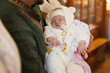 © New Africa - Father holding his child during baptism ceremony in church, closeup