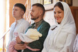 © New Africa - People with child during baptism ceremony in church