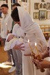 © New Africa - Mother holding her child during baptism ceremony in church