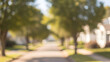 © Ofida Studio - Blurred Residential Street with Green Trees and Bokeh Lights